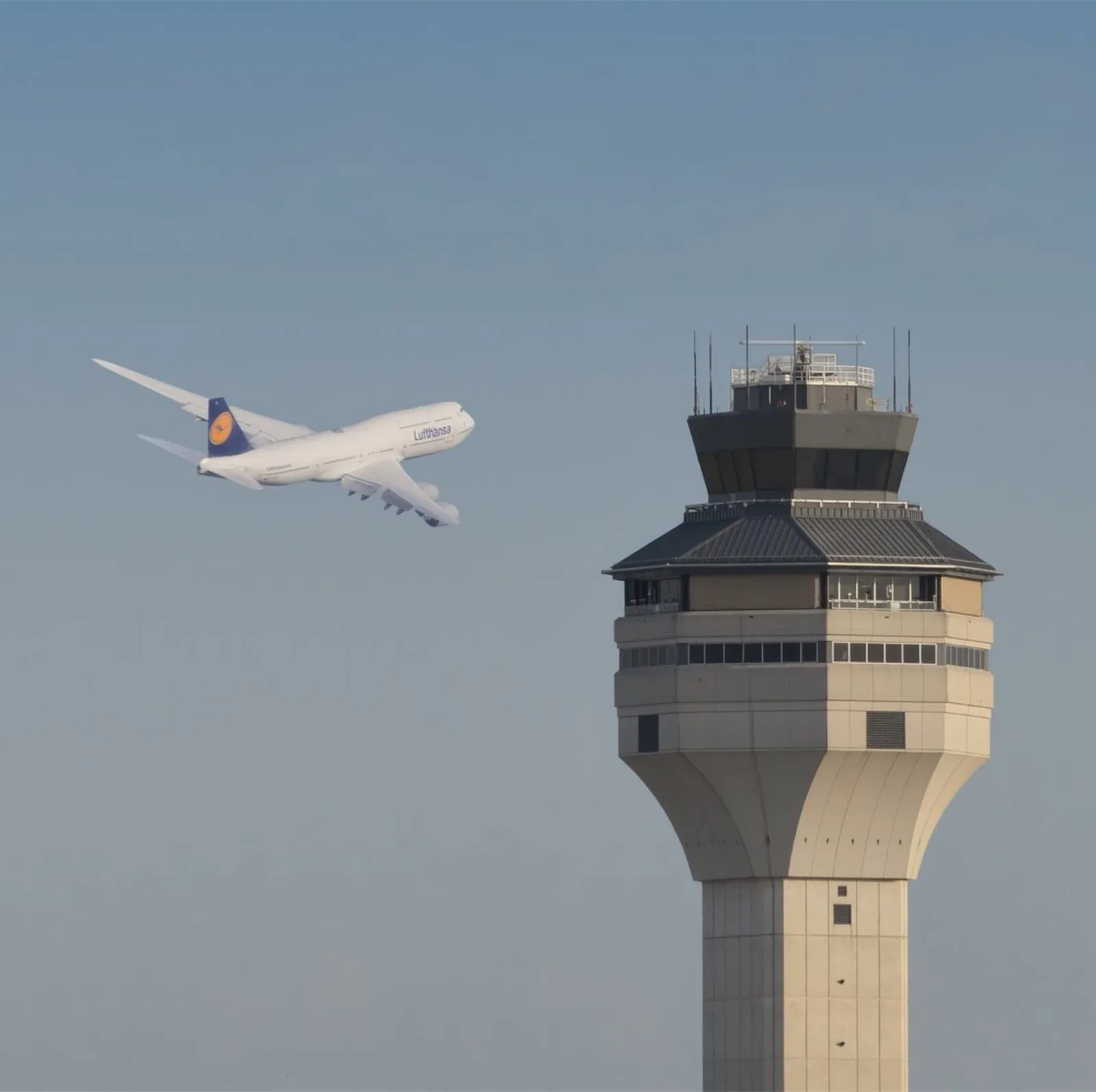 An airliner climbing past a control tower